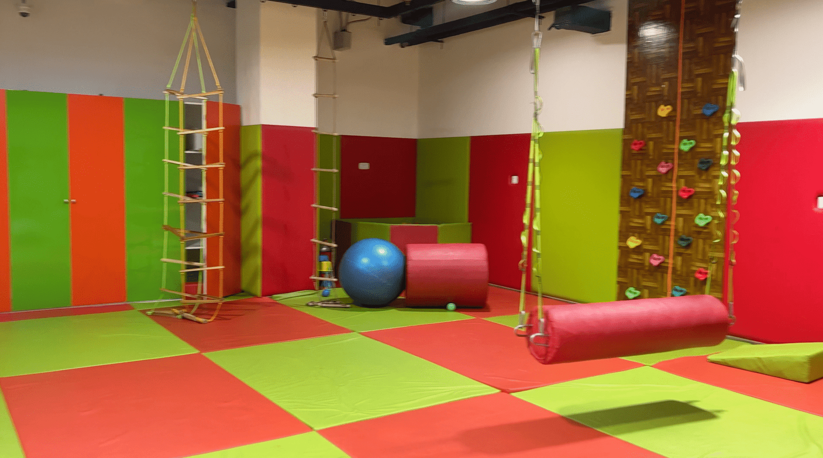 Colorful sensory integration gym with swings, climbing wall, and therapy tools at Jewel Autism Center, Dubai.